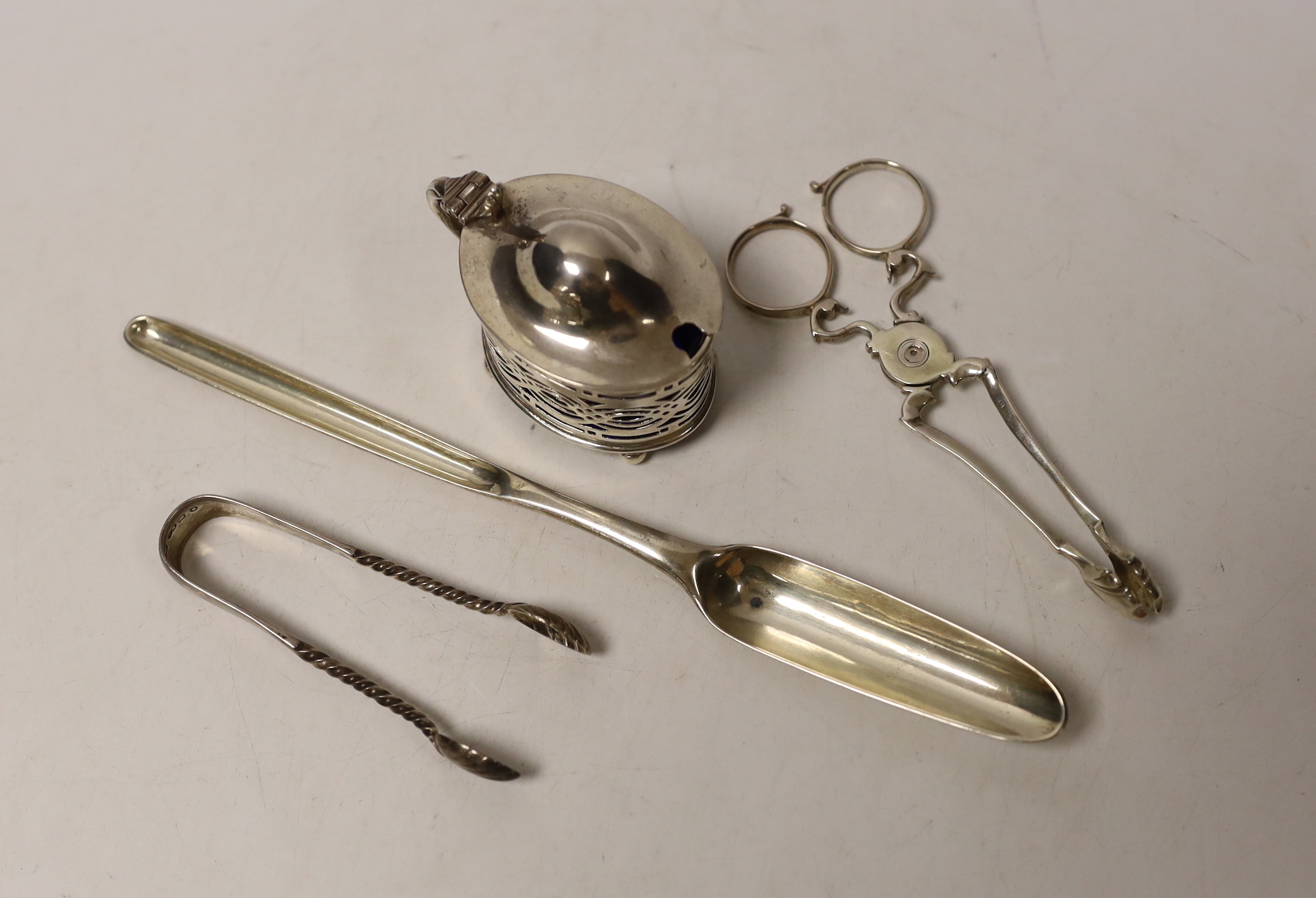 A George III silver marrow scoop, Stephen Adam, London, 1772, 21.5cm, a pair of mid to late 18th century silver sugar nips, a later silver mustard and pair of silver sugar tongs.